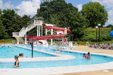 outdoor pool park with a slide, a pool a slide and water jets